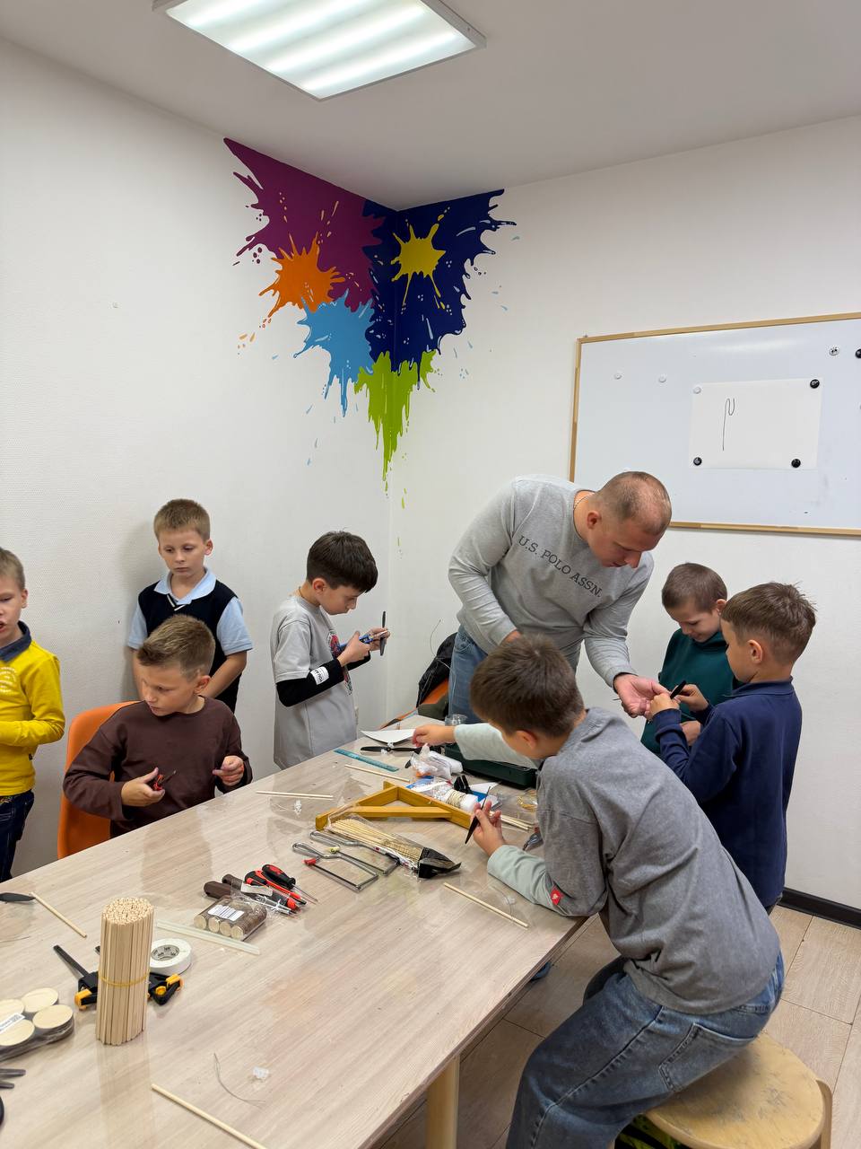 Наставник помогает детям на инженерном занятии
